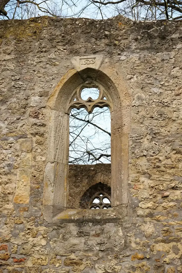 The stone walls and arched windows of St Peter's church in afternoon light
