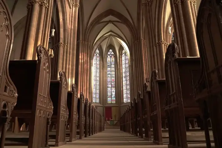 Warm light falling across the wooden pews inside St Peter's church